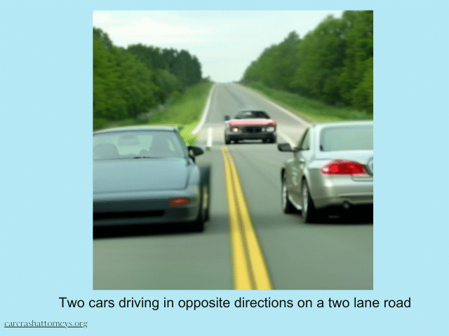 Two cars driving in opposite directions on a two lane road